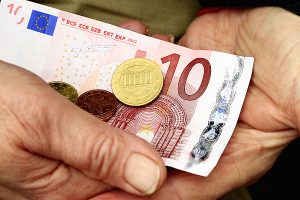 Zahlt sich Vorsorge überhaupt noch aus? 1 Ein 10 Euro Schein und eine 50 Cent Münze in den Händen einer alten Person, Stichwort Vorsorge. (c) Uschi Dreiucker_pixelio.de