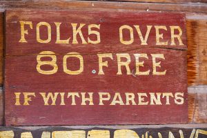 Eine Tafel mit dem Schriftzug: "Folks over 80 free. If with parents.", Stichwort dies und das. (c) FotoHiero_pixelio.de