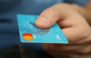 Eine Bankomatkarte in der Hand eines Mannes, Stichwort bezahlen. (c) Pixabay.com