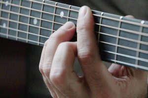 Eine Hand beim Gitarre Spielen, Stichwort neue Herausforderung. (c) Pixabay.com