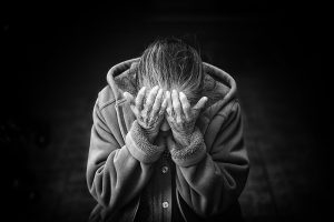 Eine alte Frau, die sich die Hände vor das Gesicht hält, Stichwort Suizid-Prävention. (c) Pixabay.com