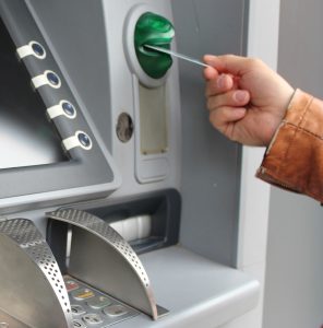 Eine Hand, die eine Bankomatkarte beim Bankomaten einführt. (c) Pixabay.com