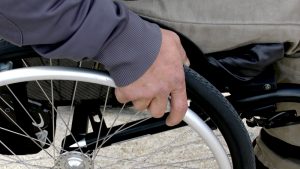 Die Hand eines Mannes an seinem Rollstuhlrad, Stichwort Hilfswerk. (c) Pixabay.com