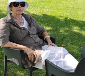 Eine Seniorin mit Sonnenbrille und Hut auf einem Gartensessel, Stichwort Kleidung für Senioren. (c) Pixabay.com