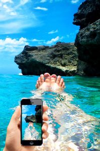 Ein Mann im Meer mit einem Smartphone, Stichwort Roaming. (c) Pixabay.com