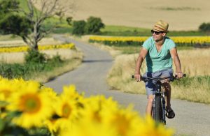 Ein Radfahrer mit Strohhut und Sonnenbrille im Sommer, Stichwort Land der Sonne. (c) NTG/ steve.haider.com