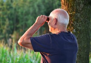 Ein alter Mann schaut durch einen Feldstecher, Stichwort gesund alt werden. (c) Pixabay.com