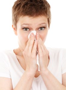 Eine Frau, die sich die Nase putzt, Stichwort Erkältungsbad. (c) Pixabay.com