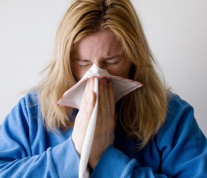 Eine Frau, die sich die Nase putzt, Stichwort Erkältungsmythen. (c) Pixabay.com