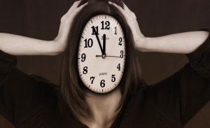 Eine Uhr als Gesicht, Hände die sich den Kopf halten, Stichwort gesunder Stress. (c) Pixabay.com