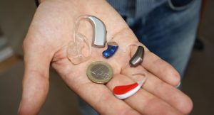 Test: Hörgeräte-Akustiker Hansaton mit bester Beratung in Ö 1 Hörgeräte im Vergleich zu einer Euro-Münze auf der Handfläche eines Mannes. (c) Pixabay.com