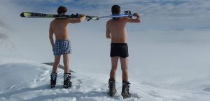 Wie sie auch bei Minunsgraden sportlich gesund unterwegs sind 1 Zwei Männer in Unterhose mit Schischuhen und Ski auf den Schultern, Stichwort sportlich gesund unterwegs. (c) Pixabay.com
