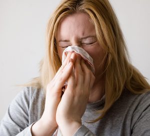 Eine Frau, die sich die Nase putzt, Stichwort Immunsystem. (c) Pixabay.com