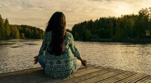Eine Frau an einem See bei einer Meditation. (c) Pixabay.com