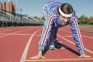 Eine Frau beim Start auf einer Laufbahn, Stichwort Sportpause. (c) Pixabay.com