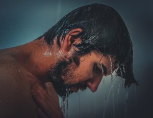 Der Kopf eines Mannes beim Duschen, Stichwort Wasser im Ohr. (c) Pixabay.com