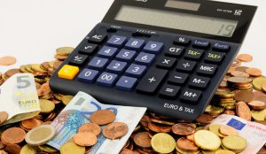 Ein Taschenrechner auf Euro-Münzen und Scheinen, Stichwort Pflegeversicherung. (c) Pixabay.com