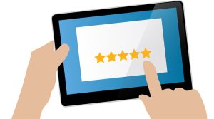 Grafik: jemand hält ein Tablet und tippt mit dem Finger auf eine Sternchenbewertung, Stichwort Bewertungsportale. (c) Pixabay.com