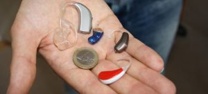 Altersmedizin – Herausforderung in der HNO-Heilkunde 1 Hörgeräte im Vergleich zu einer Euro-Münze auf einer Handfläche, Stichwort Altersmedizin. (c) Pixabay.com