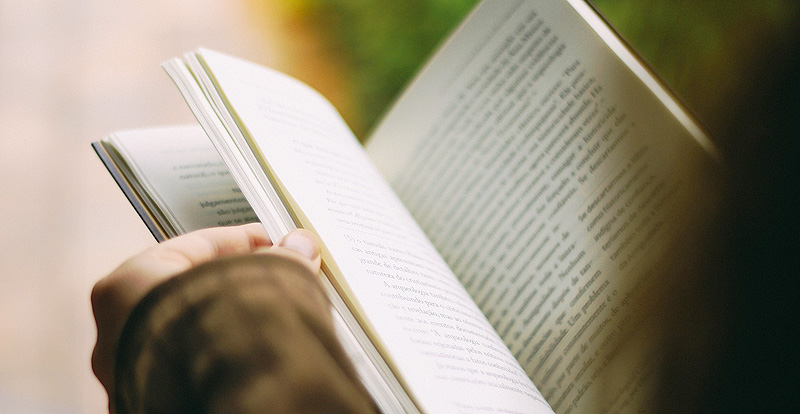 Eine Person blättert in einem Buch, Stichwort zufrieden altern. (c) Pixabay.com