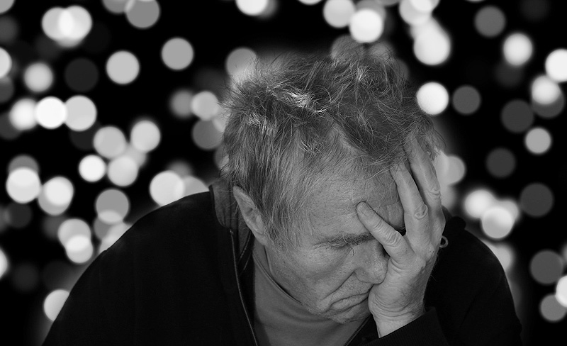 Ein alter Mann hält sich mit einer Hand den Kopf, Stichwort Demenz. (c) Pixabay.com