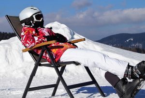 Ein Schifahrer, der auf einem Sessel die Sonne genießt.