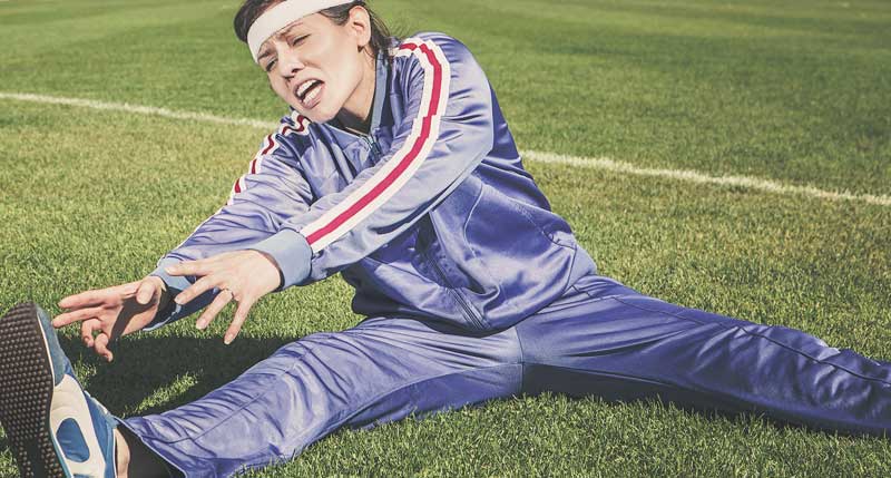 Eine Frau in Trainingsanzug  beim Dehnen mit verzerrtem Gesicht, Stichwort Frühjahrsputz für den Körper.
(c) Pixabay.com