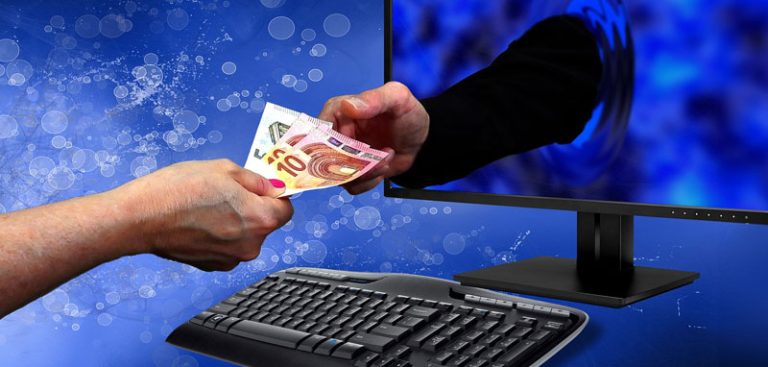 Die Hand einer Frau, die einer aus einem Monitor ragenden Hand eines Mannes Geldscheine gibt. (c) Pixabay.com