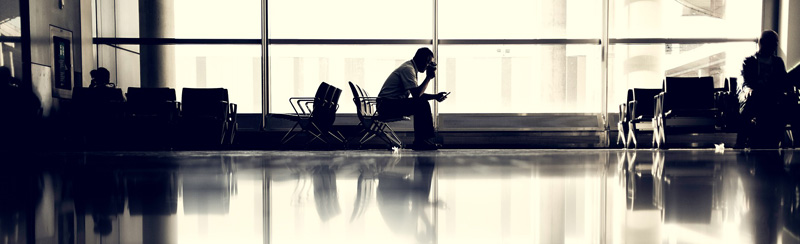 Ein wartender Mann auf einem Flughafen, Stichwort Reisekompass. (c) Pixabay.com