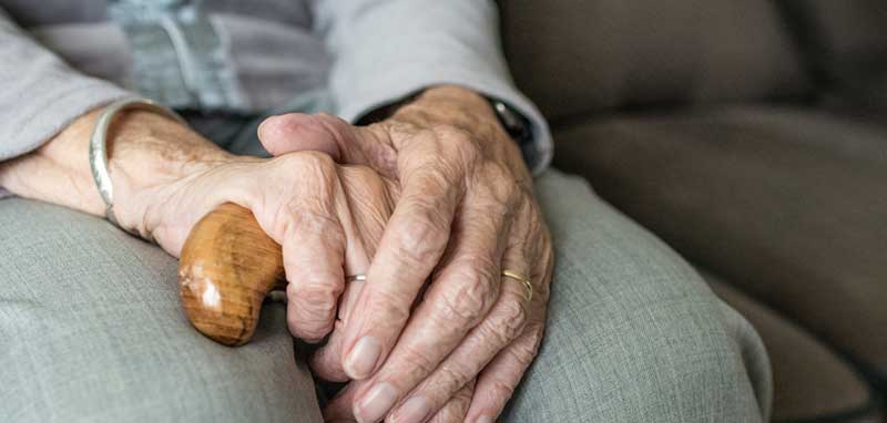 Die Hände einer alten Frau mit einem Gehstock. (c) Pixabay.com