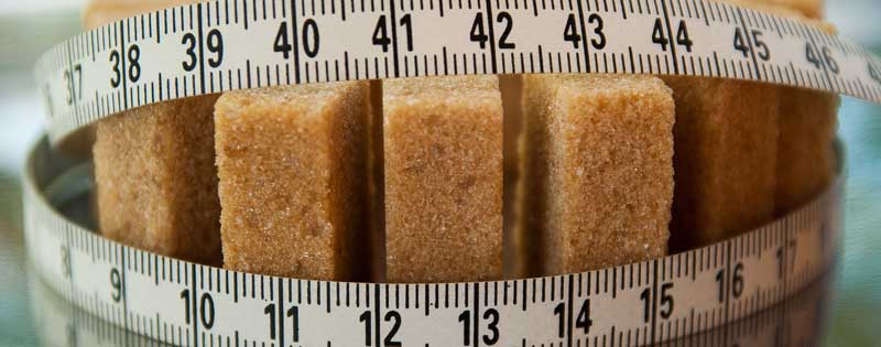 Zucker ist eine Droge und macht süchtig – Zuckermythen im Check 2 Ein Maßband um braune Würfelzucker. (c) Pixabay.com