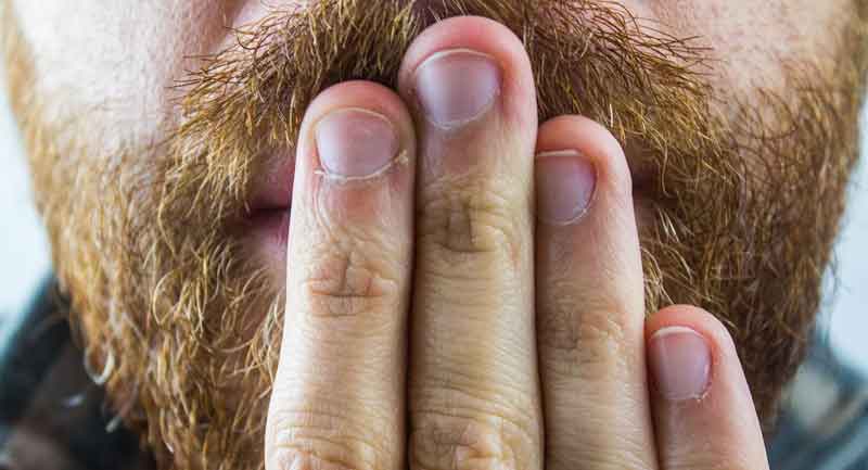 Mundgeruch: lästig, unangenehm, peinlich und was dagegen hilft 2 Ausschnitt: der Mund eines Mannes mit Bart, der sich die Hand davor hält. (c) Pixabay.com