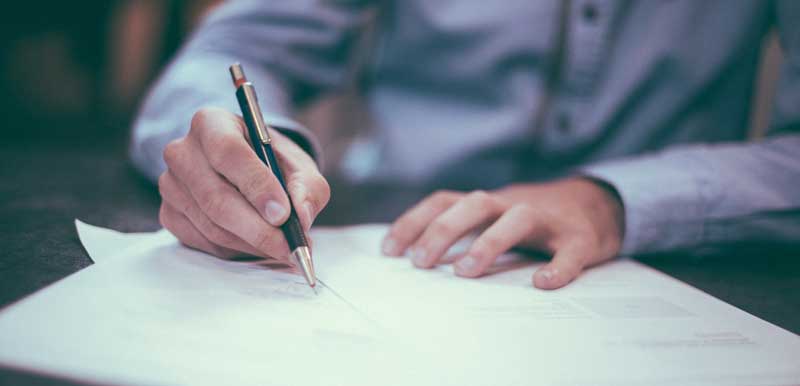 Versicherungen regelmäßig checken – für den Fall des Falles 2 Ein Mann, der auf einem Blatt Papier etwas schreibt. (c) Pixabay.com