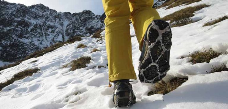 Schuhe einer Wanderin beim Wandern in höheren Lagen beim Überqueren eines Altschnee-Feldes. (c) Alpenverein/ Larcher