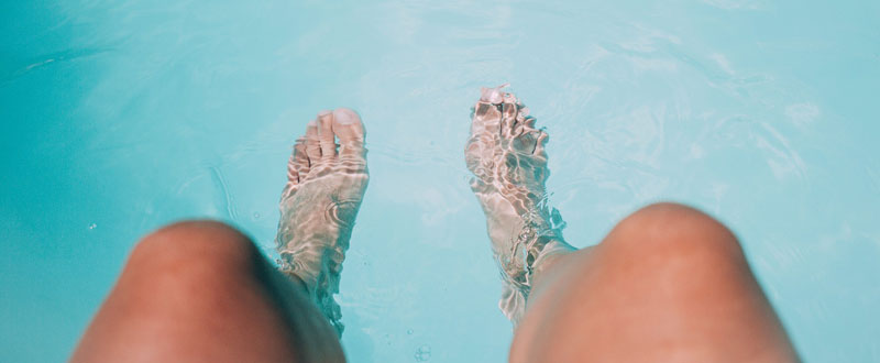 Füße, die in einen Pool hängen. (c) Pixabay.com