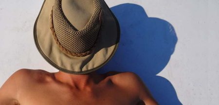 Ein Mann beim Sonnenbaden mit einem Hut auf seinem Gesicht. (c) Pixabay.com