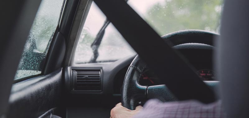 #Mobilität – ohne Führerschein ist man nur mehr ein halber Mensch 2 Ausschnitt eines Autofahrers von hinten; man sieht das Lenkrad, und dass es regnet. (c) Pixabay.com
