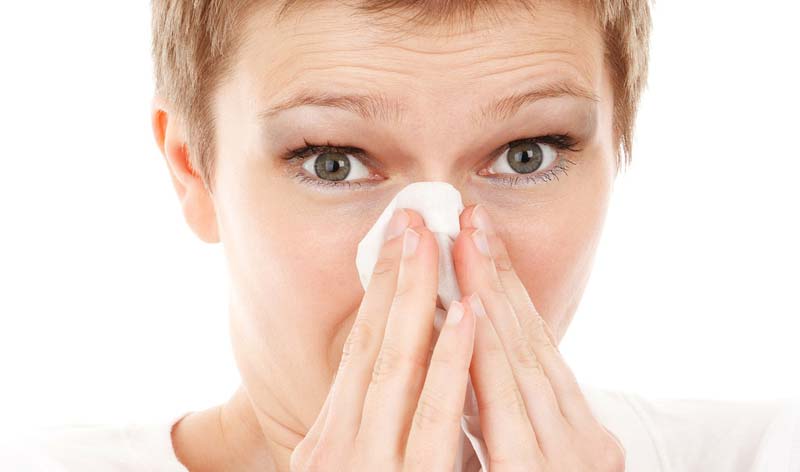 Eine Frau, die sich die Nase putzt. (c) Pixabay.com