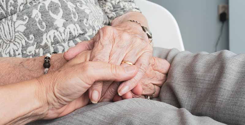 Die Hand einer Frau, die die Hand einer alten Frau hält. (c) Pixabay.com
