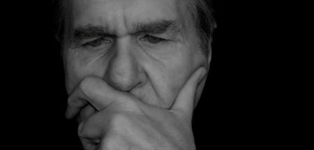 Das Gesicht eines nachdenklichen älteren Mannes, der eine Hand vor seinem Mund hält. (c) Pixabay.com