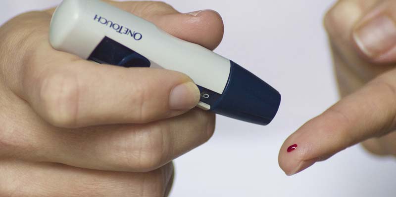 Ein Bluttropfen auf einem Zeigefinger, in der anderen Hand ein Blutzuckermessgerät. Das Risiko, an Demenz zu erkranken, ist für Diabetiker höher. (c) Pixabay.com