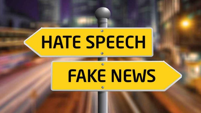 Zwei Wegweise – Hate Speech, Fake News – vor einer im Hintergrund verschwommenen Straße. (c) HPI Hasso-Plattner-Institut
