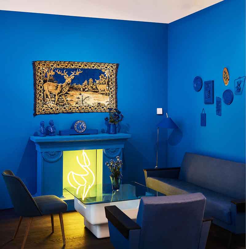 Blauer Salon mit beheizbarem Neonkamin im Generationencafé Vollpension.  (c) Vollpension/ Mark Glassner