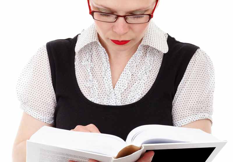 Eine Frau mit Brille hält ein dickes Buch, in dem sie liest. (c) Pixabay.com