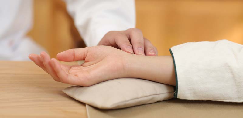 Die Hand eines Arztes, der einer Frau mit den Fingern den Puls misst. (c) Pixabay.com