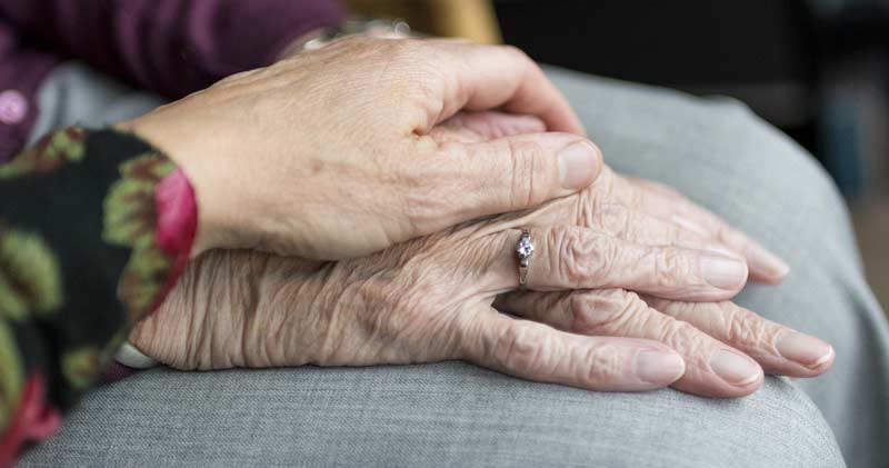 Eine Frau legt tröstend ihre Hand auf die Hände einer alten Frau, Stichwort Pflegepersonal. (c) Pixabay.com