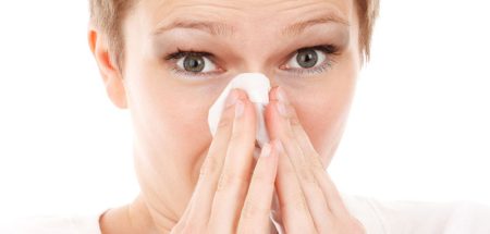 Das Gesicht einer Frau, die sich die Nase putzt. (c) Pixabay.com