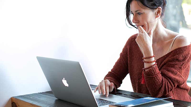 Eine Frau an einem Tisch vor einem Laptop, Stichwort Preissuchmaschine. (c) Pixabay.com