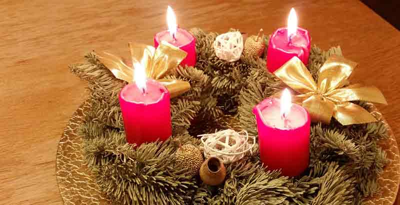 4 brennende Kerzen auf einem Weihnachtsgesteck mit Tannenzweigen. (c) Pixabay.com