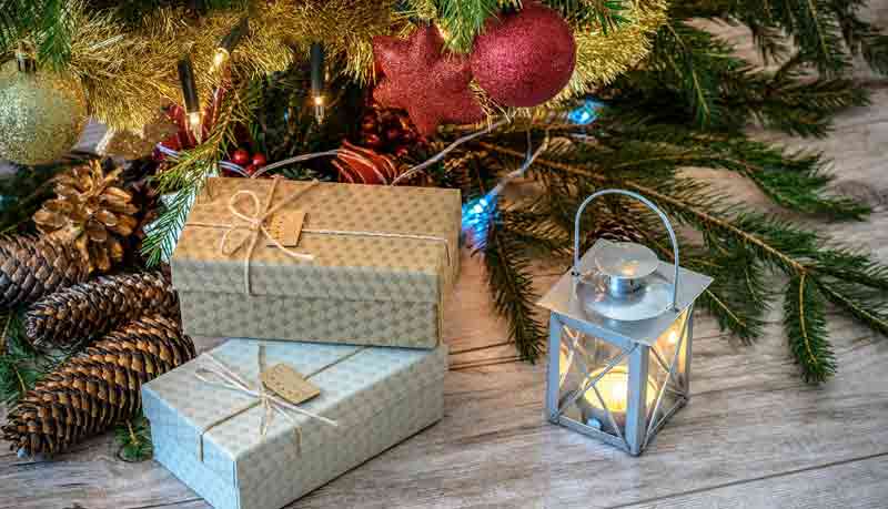 Weihnachtspackerl, Tannenzweige und ein Windlicht. (c) Pixabay.com